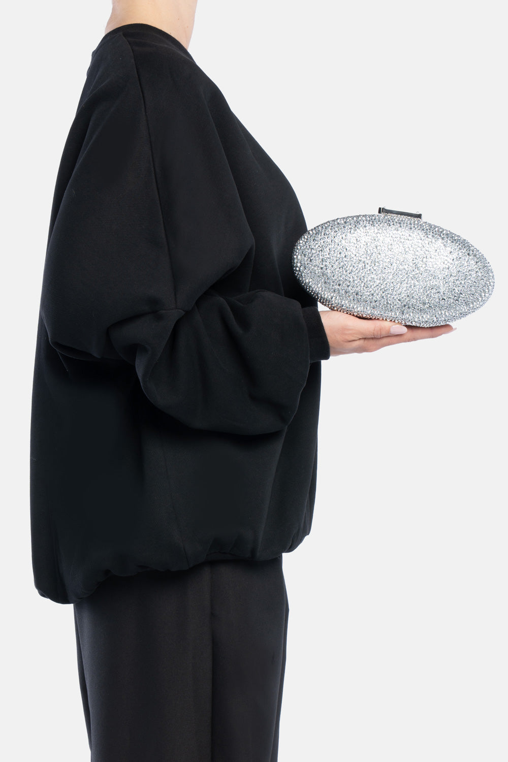 Clutch indare argento, portata a mano dalla modella. TWENTYFOURHAITCH.