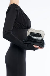 Clutch tyrene nera, portata a mano dalla modella. TWENTYFOURHAITCH.