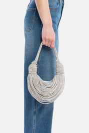 Handbag tome argento, portata a mano dalla modella. TWENTYFOURHAITCH.