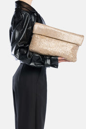 Maxi pouch dunham metal oro, portata a mano dalla modella. TWENTYFOURHAITCH.