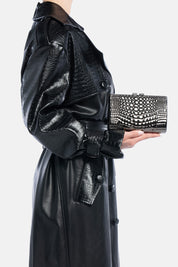 Mini clutch Aevel color canna di fucile, in metallo effetto croco, portata a mano dalla modella – TWENTYFOURHAITCH.
