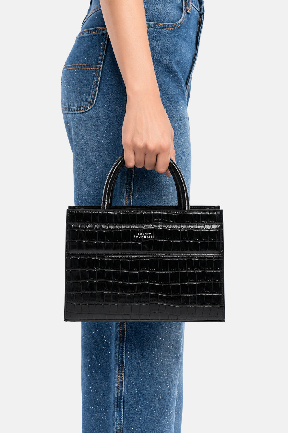 Mini tote bag serane nera croco, portata a mano dalla modella. TWENTYFOURHAITCH.