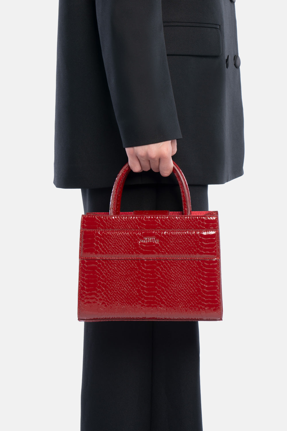 Mini tote bag serane rossa pitonata, portata a mano dalla modella. TWENTYFOURHAITCH.