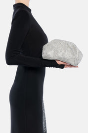 Petra pouch bag argento, portata a mano dalla modella. TWENTYFOURHAITCH.