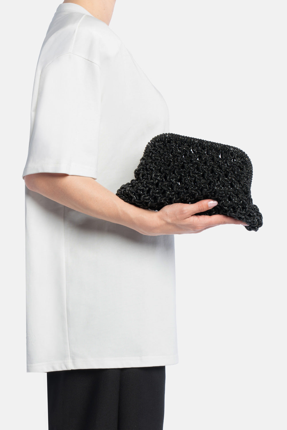 Pochette kaira nera, portata a mano dalla modella. TWENTYFOURHAITCH.