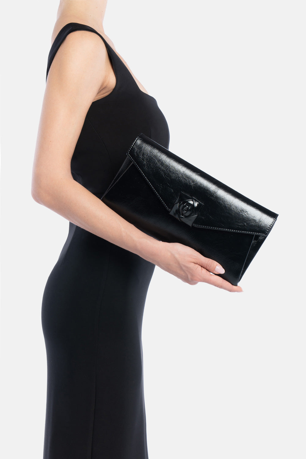 Pochette larken nera in vernice, portata a mano dalla modella. TWENTYFOURHAITCH.