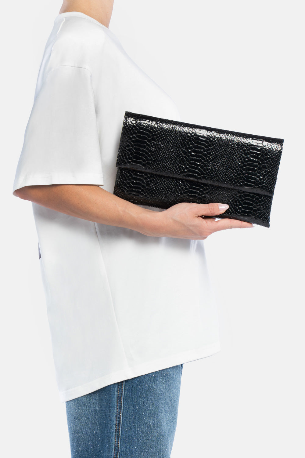 Pochette nireya nera, portata a mano dalla modella. TWENTYFOURHAITCH.