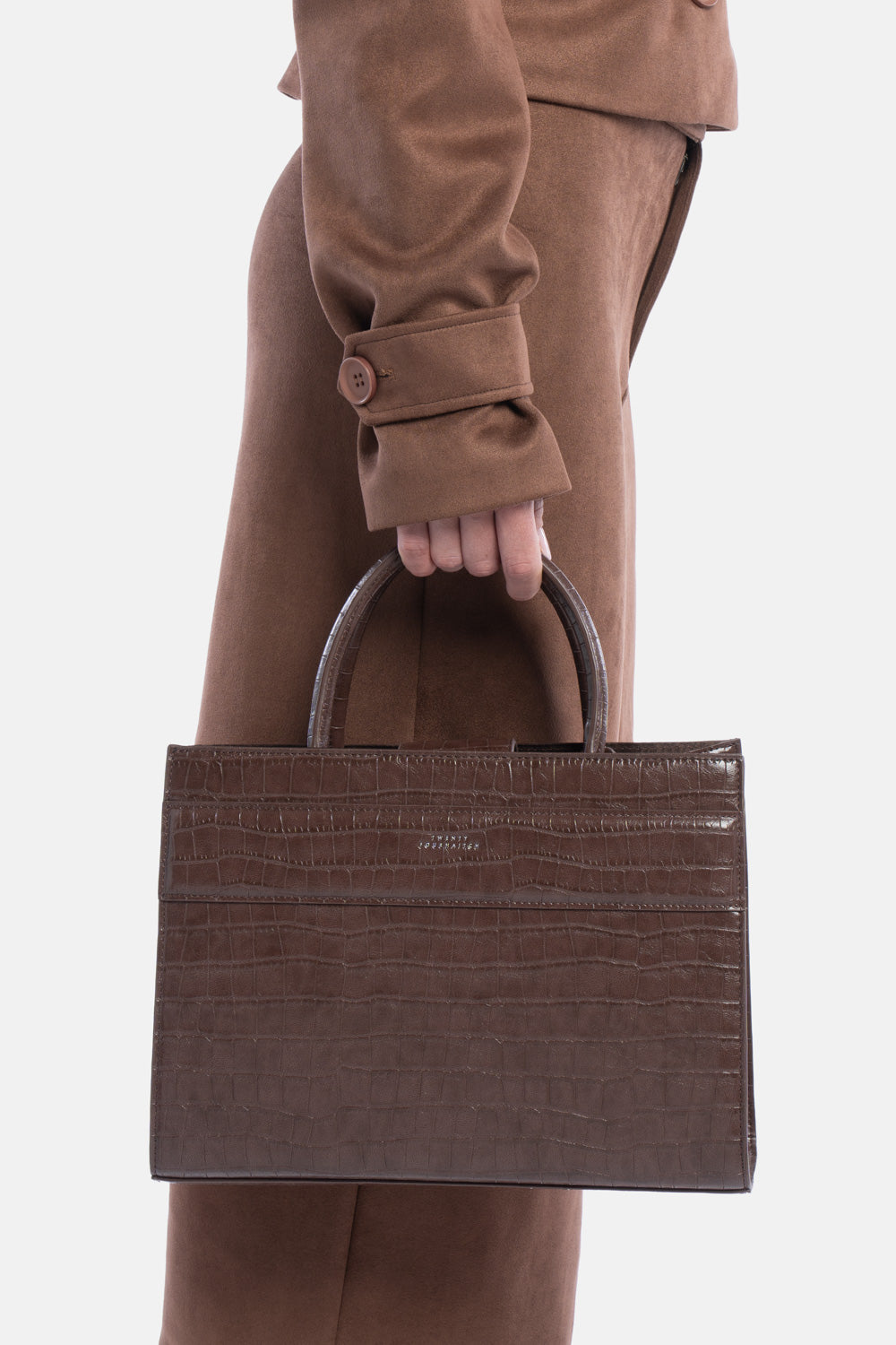 Tote bag serane marrone croco, portata a mano dalla modella. TWENTYFOURHAITCH.